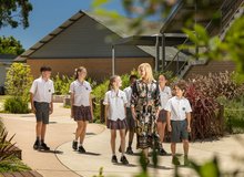 A teacher and students walking outdoors.