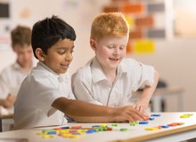 Students working at a table in a classroom.