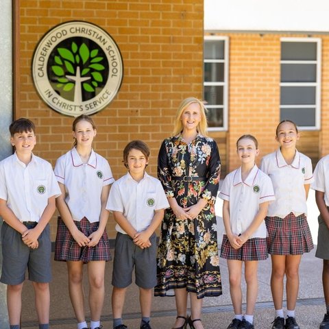 A teacher standing with a group of students.